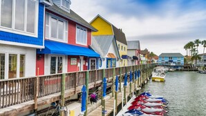 A waterfront property with colorful buildings, a wooden dock, and boats docked along the water. - Perfect 2 Bedroom Apartment on The Anchorage, Siesta Key Apartment 1020 (Siesta Key)
