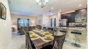 A modern kitchen with dark cabinets, stainless steel appliances, and a granite countertop. - Beautiful 5 Star Townhome on Storey Lake Resort with Private Pool, Orlando Townhome 4807 (Orlando)