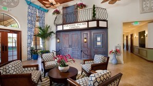A lobby with a seating area, a balcony with a sign reading "Paradise Palms Cinema," and a hallway with doors.