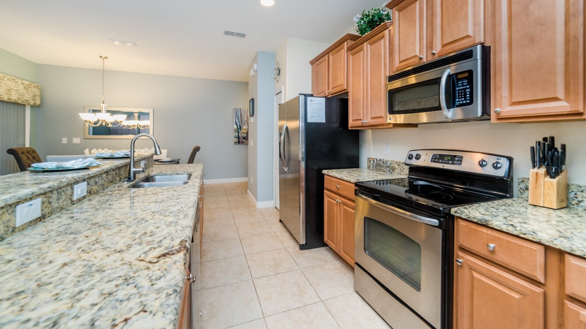 A modern kitchen with granite countertops, stainless steel appliances, and wooden cabinets.