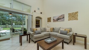 A modern living room with a sectional sofa, a coffee table, and decorative wall art. - Exclusive 5 Star Villa with Private Pool on Windsor Palms Resort, Orlando Villa 4903 (Orlando)