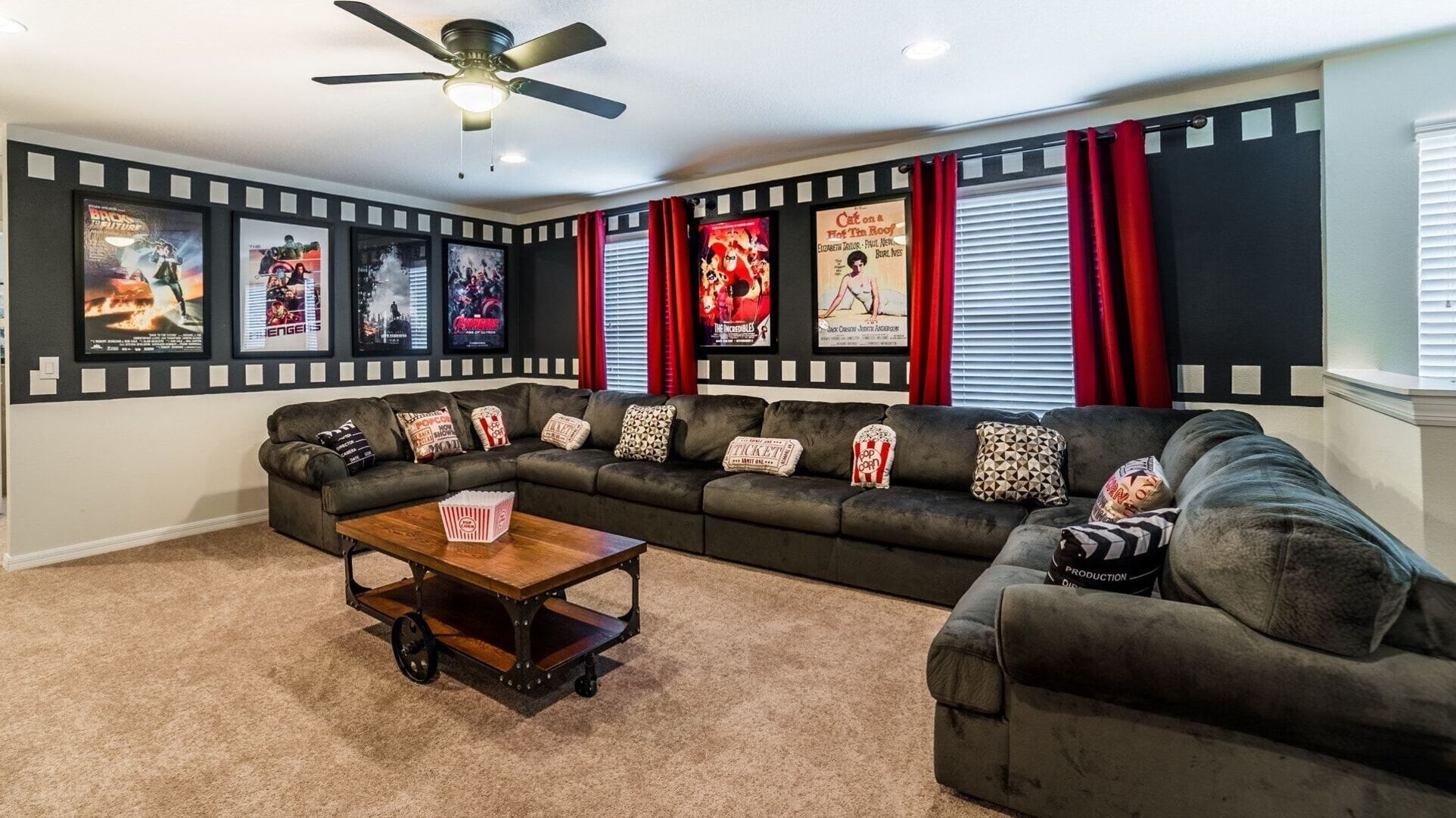 A living room with a sectional sofa, a coffee table, and a ceiling fan.