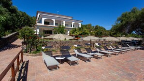 A resort with a pool area, sun loungers, and umbrellas. - Holiday Apartment 'Pavoncella' with Wi-Fi, Garden & Shared Pool (Orosei)