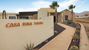 A building labeled 'CASA RURAL TERME' with a paved pathway, cacti, and palm trees.