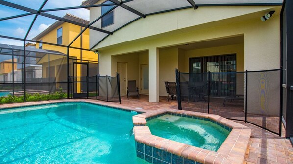 Relax by the pool surrounded by a patio with outdoor furniture.