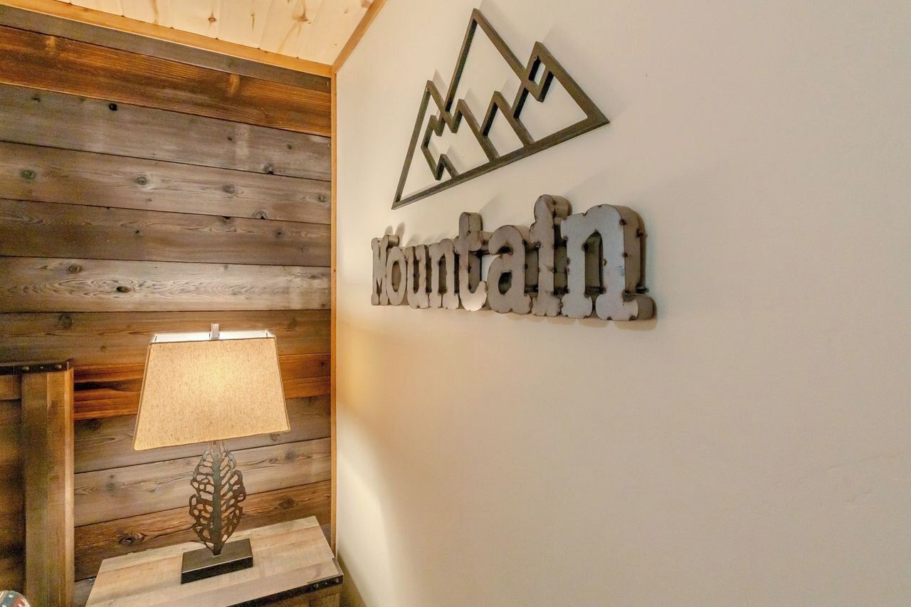 Un mur en bois sur lequel est fixée une plaque métallique portant l’inscription « Mountain » et représentant la silhouette d’une montagne.
