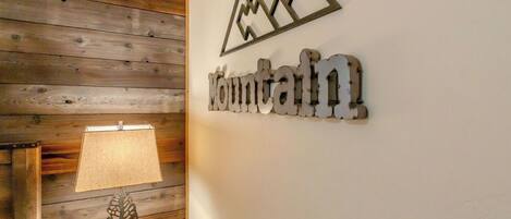 Un mur en bois sur lequel est fixée une plaque métallique portant l’inscription « Mountain » et représentant la silhouette d’une montagne.