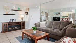 Un salon avec un canapé, une table basse, une cheminée et un téléviseur.