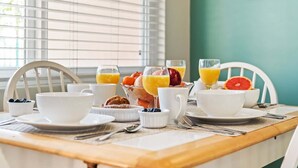 Une table de petit-déjeuner avec des tasses, des verres et des fruits.