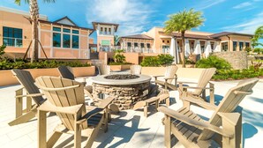 An outdoor seating area with Adirondack chairs and a stone fire pit.