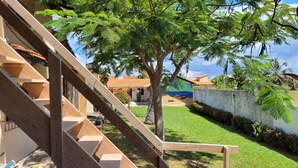 A wooden staircase leading to a house with a garden, a palm tree, and a mural on the wall. - Pousada Vila Cajuína - Luís Correia (Luis Correia)