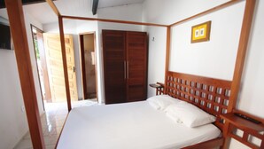 A bedroom with a wooden bed, a wardrobe, and a small bedside table. - Pousada Vila Cajuína - Luís Correia (Luis Correia)