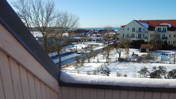 A residential area with houses, a river, and snow-covered ground. - Ferienwohnung Rerik - Ferienwohnung (Rerik)