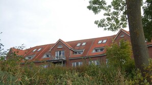 A large brick building with multiple windows and a red-tiled roof. - Ferienwohnung Rerik - Ferienwohnung (Rerik)