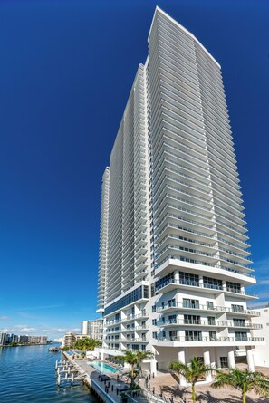Un grand hôtel moderne doté de nombreux balcons et offrant une vue sur le front de mer.