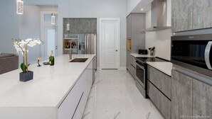 A modern kitchen with a central island, stainless steel appliances, and a minimalist design.