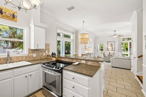 A modern kitchen with granite countertops, stainless steel appliances, and a view of the outdoors.
