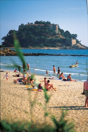 A beach with people sunbathing and swimming, a castle on a hill in the background, and a clear blue sky. - Charming 3-star villa with the "Var" quality label in a Provençal hamlet - Wi-Fi (Bormes-les-Mimosas)