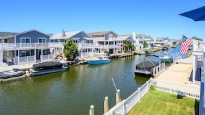 A waterfront property with docked boats, a grassy area, and a view of the water. - Canal Front Views, Boat Dock, Kayaks, 10" Walk to the Beach, Free Activities inc. Golf at Bear Trap. (Fenwick Island)