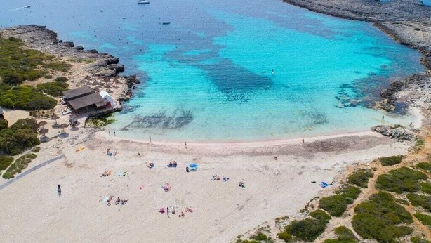 An aerial view of a beach with clear turquoise waters, rocky outcrops, and a few boats. - 3min. Walk to the beach, Villa Bini  Perla, sea view, sunny, quiet location (Binibequer)