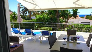 An outdoor patio with a table, chairs, and a pool area. - 3min. Walk to the beach, Villa Bini  Perla, sea view, sunny, quiet location (Binibequer)