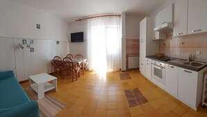 A compact living space with a kitchenette, a dining area, and a sofa. - Apartment Paulinic (Rovinj)