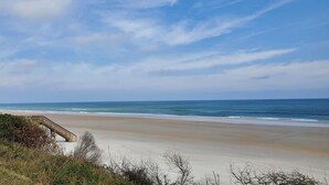 A beach with a wooden staircase leading down to the shore, surrounded by vegetation. - 361 Fun in the Sun- Direct Oceanfront Ground Floor, 361 Fun in the Sun Summerhouse (Crescent Beach)