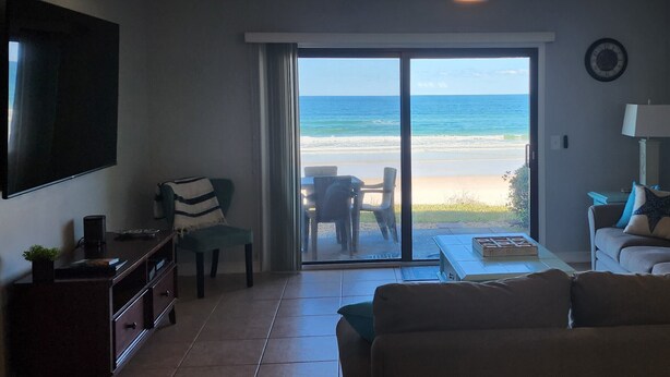 A living room with a large sliding glass door leading to a beach view. - 361 Fun in the Sun- Direct Oceanfront Ground Floor, 361 Fun in the Sun Summerhouse (Crescent Beach)