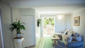 Uma sala de estar com sofá, mesa de centro e planta em vaso.