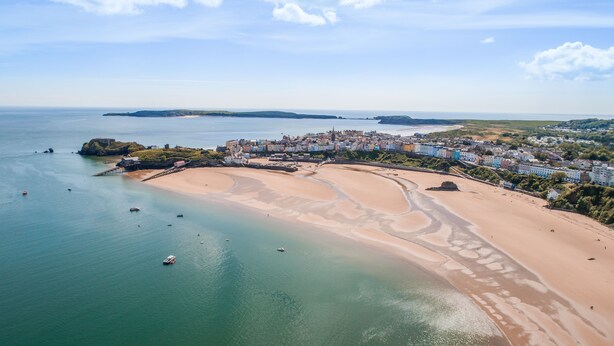An aerial view of a coastal town with a sandy beach, a small island with a fort, and a densely built area with colorful buildings. - Brofallen - A secluded retreat with breathtaking views (Laugharne (1.8miles W))