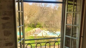 An open door leading to a balcony with a view of a garden and a swimming pool. - calm and nature, with private pool (vindrac-alayrac)