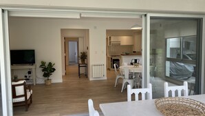 A modern apartment with a dining area, kitchen, and a TV in the living room. - Fantastico Duplex Con Jardin y Piscina (Villa San Lorenzo)