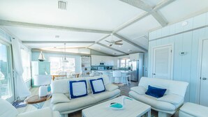 A spacious living area with a white sofa set, a coffee table, and a dining area with a white table and chairs. - Beaulieu-Sur-Duck - Sanderling, Ocean View, Steps to Direct Boardwalk, Pets OK, Flex Stays (Duck)