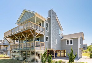 A two-story house with a balcony and a covered porch.