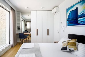 A hotel room with a bed, a desk, and a wardrobe.