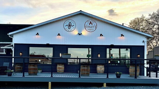 A building with two signs: "RISING RIVER BREWING CO." and "CURLEY'S BARBECUE." - Downtown Studio at The Lake -Unit 4 (Conneaut Lake)