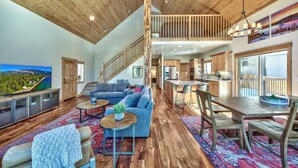 A spacious living area with a large TV, a sofa, and a dining table.