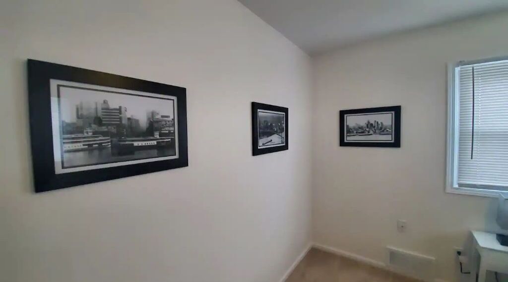 Un couloir orné de trois photographies en noir et blanc encadrées.