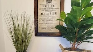 A wooden bench with a framed notice and two potted plants.