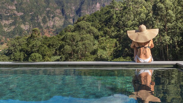 A person relaxing by a pool with a mountainous backdrop. - In Laurissilva Forest, Casa do Lanço -Carvalho (São Vicente)