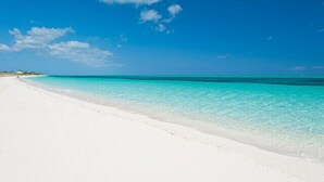 A beach with clear turquoise water and white sand.