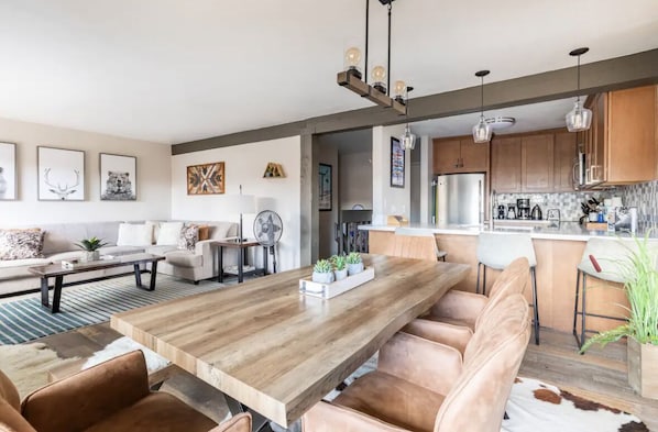 Una cocina moderna con armarios de madera, una isla central e iluminación colgante.