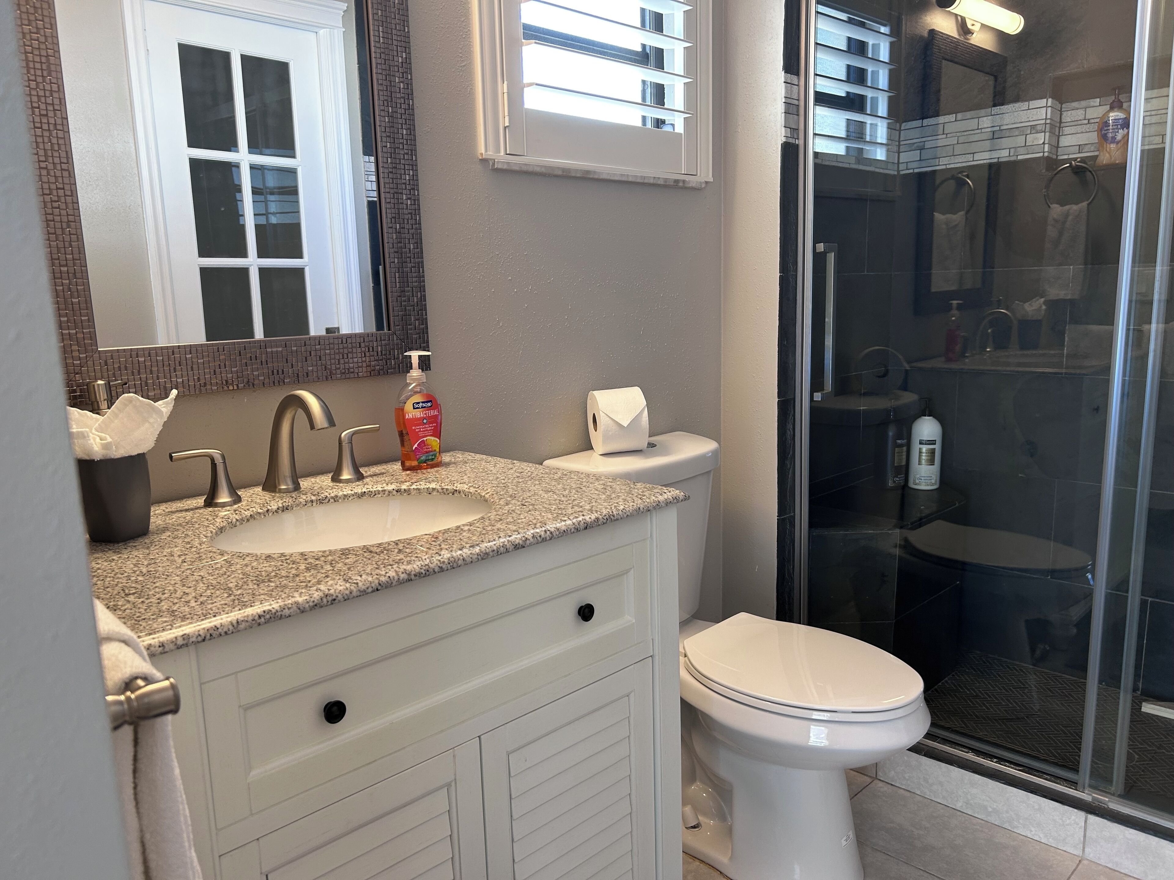 A bathroom with a sink, toilet, and shower.