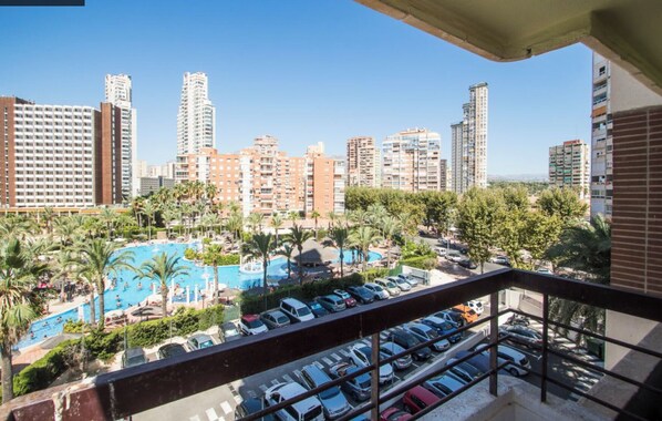 A hotel with a pool area, multiple parking levels, and a view of surrounding high-rise buildings.