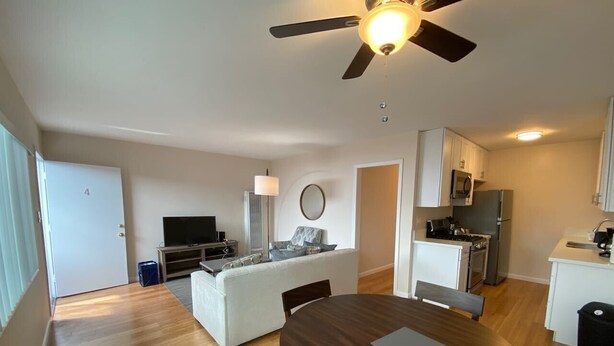 Un appartement moderne comprenant un coin repas, une cuisine et un salon.