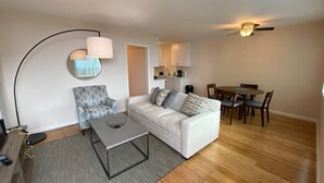 Un salon comprenant un canapé, une table basse et un coin repas avec des chaises et une table.