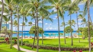 Un resort tropical con palmeras, una playa y un cielo azul cristalino.