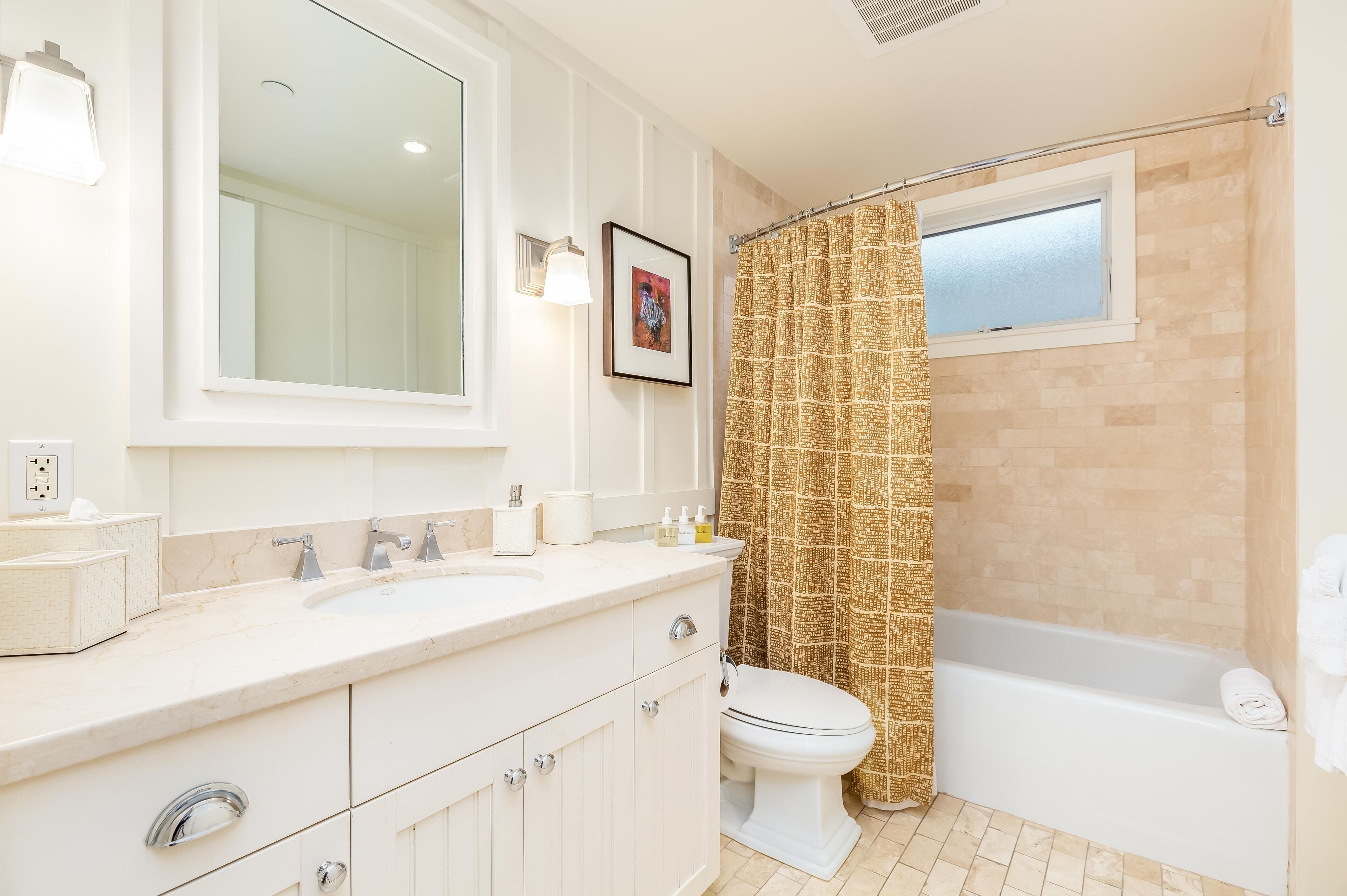 A bathroom with a double sink vanity, a toilet, a bathtub, and a shower curtain.