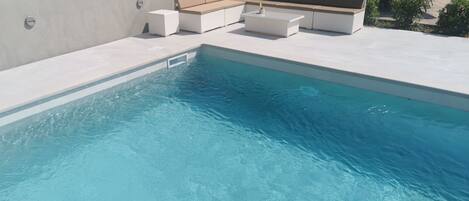 Een buitenzwembad en een verwarmd zwembad