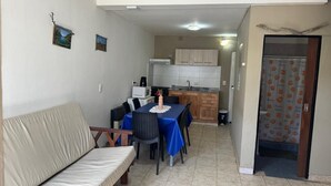Un espace de vie compact comprenant un coin repas, une kitchenette et un canapé.